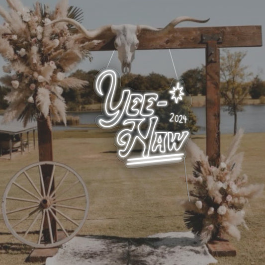 A vibrant neon sign in bold, Western-style font that reads 'Yew Haw 2024,' evoking the spirited essence of the Wild West, perfect for adding cowboy chic to wedding or event decor