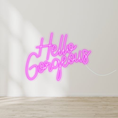 A hot pink neon 'Hello Gorgeous' sign, glowing brightly and adding a pop of color to the room perfect for beauty or nail room